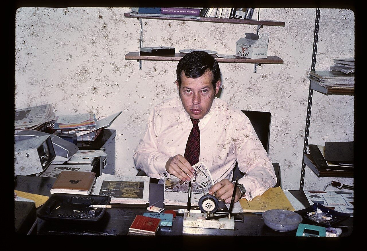 Alan Hellmann at his desk holding a deck of cards